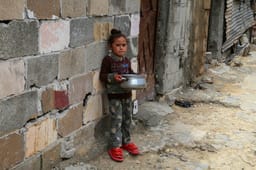 Palestinians receive meals from the World Kitchen in Khan Yunis, on March 22, 2025. 