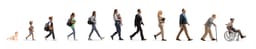 Full length profile shot of a group of people walking, from a baby crawling to a senior