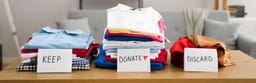 Piles of clothes to keep or discard.