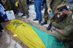 Family and friends of Israeli soldier First sergeant Nir Gofer mourn near his fresh grave after his funeral at the Military Cemetery in Sderot on November 14, 2024