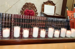 Memorial candles next to seforim published by Rabbi Mazuz ztz"l