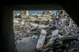 Palestinians inspect the rubble of the Ahmed family's home after it was bombed in an Israeli airstrike