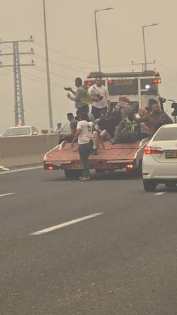 People being rescued from Road 1 on the back of lorry's to escape the fire