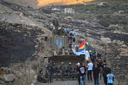 Druze residents protest near the Israeli-Syrian border fence in solidarity with their community in Syria, July 16, 2025. 