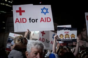 Israeli doctors hold photographs of the kidnapped people held hostage by Hamas terrorists in Gaza, as they protest outside the Red Cross headquarters in Tel Aviv, November 9, 2023.