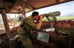 An IDF soldier looks out over southern Lebanon from an observation post near the Israeli Lebanese border