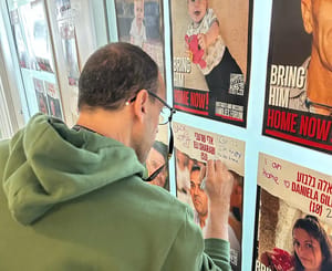 Eli Sharabi writing on his hostage poster
