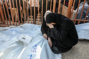 Palestinians mourn the death of Palestinians killed in an Israeli air strike outside the Nasser Hospital in Khan Yunis, in the southern Gaza Strip, March 18, 2025. 