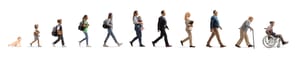 Full length profile shot of a group of people walking, from a baby crawling to a senior