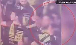 Soccer fan firing fireworks into the crowd