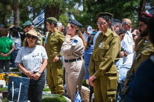People stand still as a two minutre siren sounded across Israel, marking Memorial Day which commemorates the fallen Israeli soldiers and victims of terror at Mount Herzl Military Cemetery in Jerusalem on April 30, 2025. 