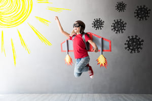  Happy child jumping with toy cardboard wings.