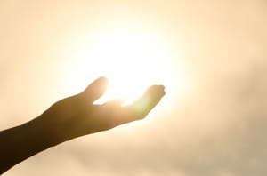 Woman's hand holding the sun 