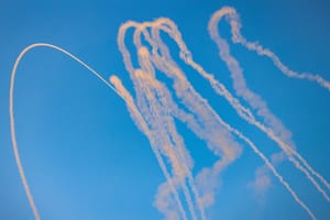 Smoke trails are seen as missiles launched from Lebanon into Northern Israel are intercepted by Israeli anti missile system