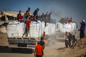 Armed Palestinians sit on trucks carrying humanitarian aid near the Zikim border crossing between Israel and Beit Lahia in the northern Gaza Strip, June 25, 2025.