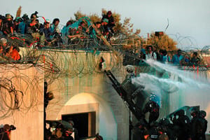 Israeli soldiers are under pressure as settlers who barricaded themselves on a roof throw water, rubbish and chemicals onto approaching security forces who are about to evacuate them from the roof of the Jewish settlement of Kfar Darom in the Gaza Strip. 