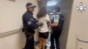 The Australian man being led off the plane in handcuffs upon landing.