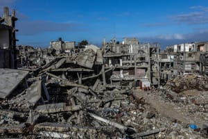 Palestinians seen near buildings destroyed in the recent war, in Khan Yunis, in the southern Gaza Strip, December 30, 2025.