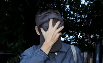 The teacher hides his face from media