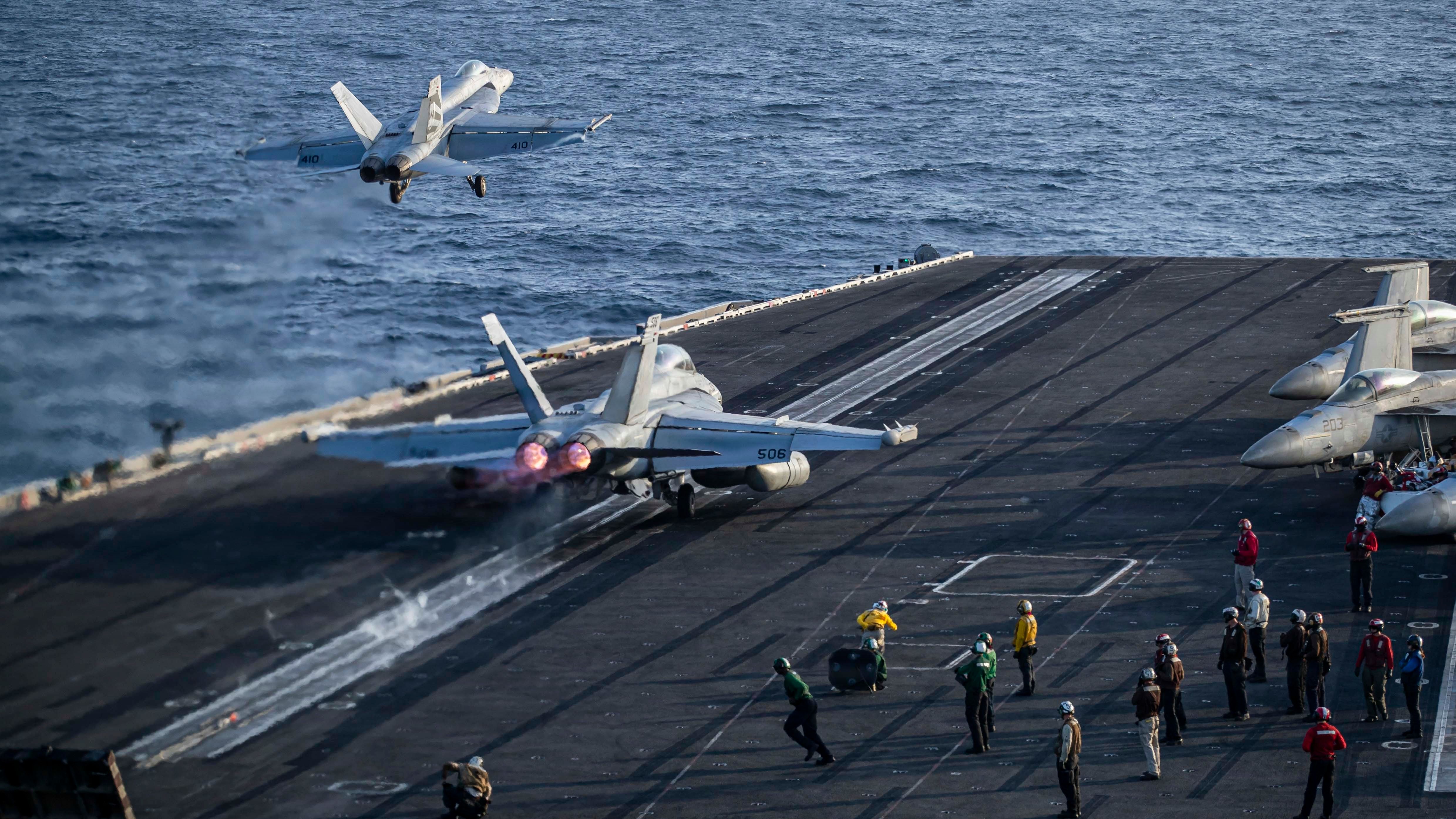 Planes taking off of USS Aircraft Carrier