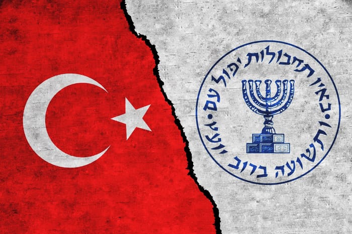Illustration. Turkey and Mossad painted flags on a wall with a crack.
