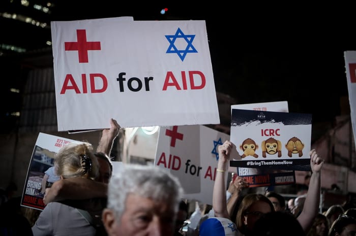 Israeli doctors hold photographs of the kidnapped people held hostage by Hamas terrorists in Gaza, as they protest outside the Red Cross headquarters in Tel Aviv, November 9, 2023.