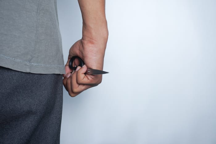 Illustrative: A person holding a pair of scissors