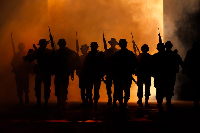 Special forces team in uniform walking action through smoke