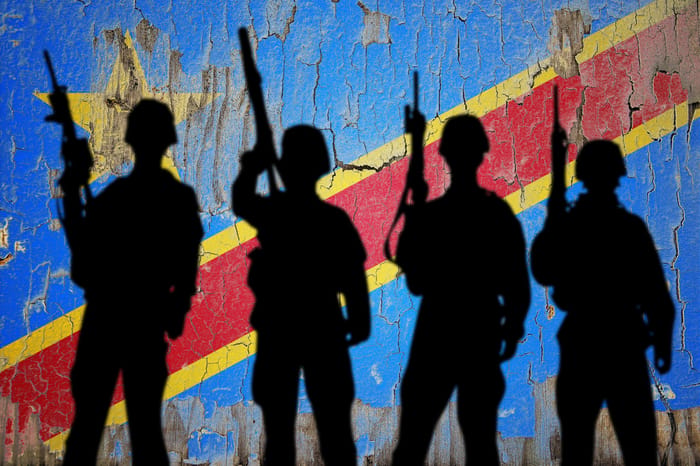 Flag of Congo Democratic painted on the cracked wall with soldier shadow. 