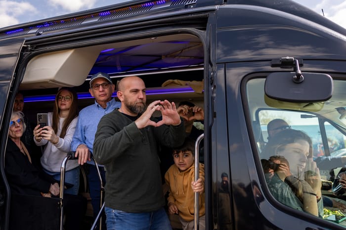 Relatives of Bibas family gesture to the crowd during the funeral service of late Israeli hostages Shiri Bibas and her children Ariel and Kfir, on road 232 in southern Israel, February 26, 2025