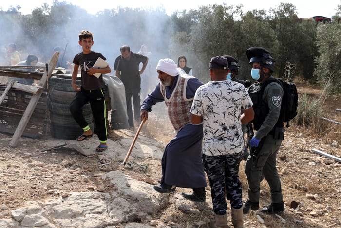 Israeli security forces argue with Palestinians as they arrive to demolish a house that was built without a permit in Yatta, Judea and Samaria