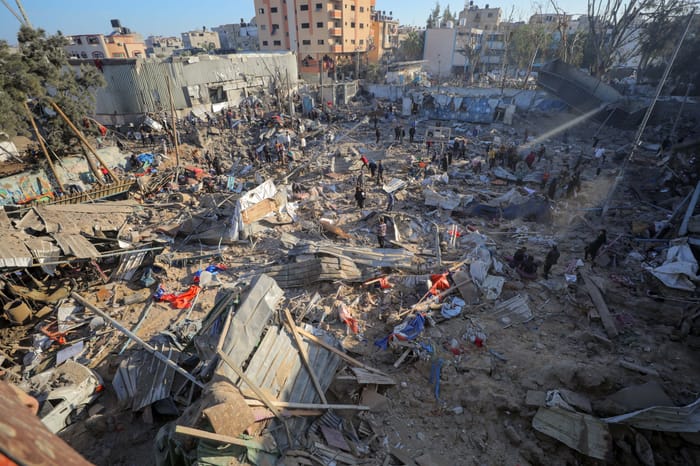 Palestinians at the site of an Israeli airstrike, in the Al-Bureij camp, in the Gaza Strip, May 7, 2025.