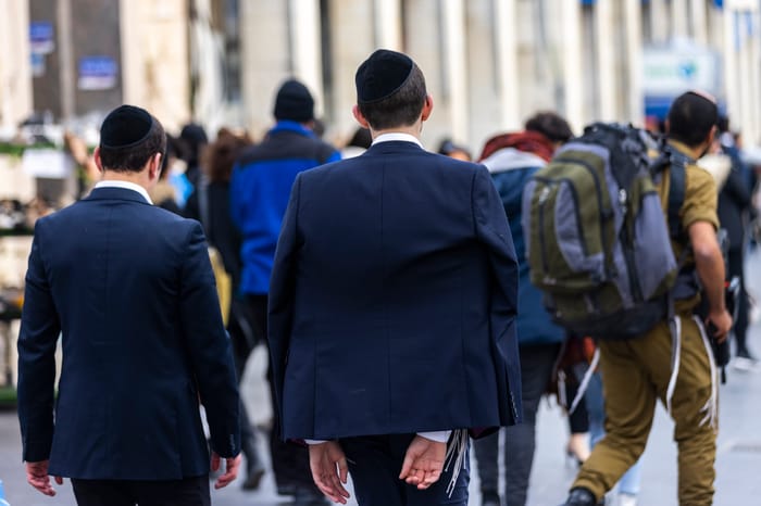 Ultra orthodox yeshiva student walk past a religious soldier on Jaffa road in Jerusalem