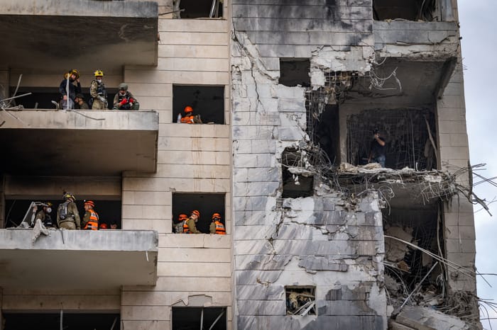 Israeli security and rescue forces at the scene where a ballistic missile fired from Iran hit and caused damage in Petah Tikva, June 16, 2025.
