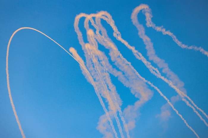 Smoke trails are seen as missiles launched from Lebanon into Northern Israel are intercepted by Israeli anti missile system
