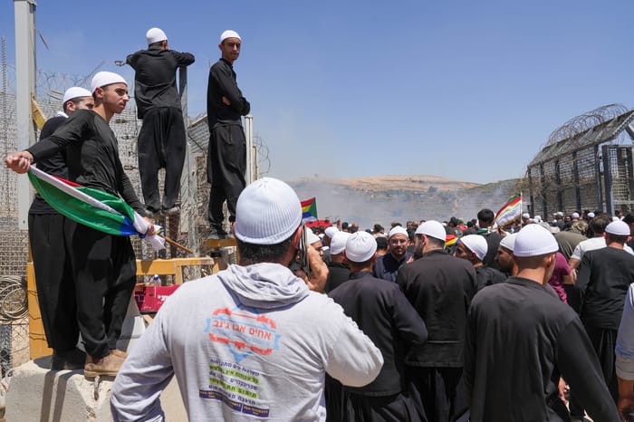 Druze residents protest near the Israeli-Syrian border fence in solidarity with their community in Syria, in Majdal Shams, July 16, 2025.