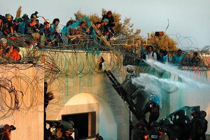 Israeli soldiers are under pressure as settlers who barricaded themselves on a roof throw water, rubbish and chemicals onto approaching security forces who are about to evacuate them from the roof of the Jewish settlement of Kfar Darom in the Gaza Strip. 