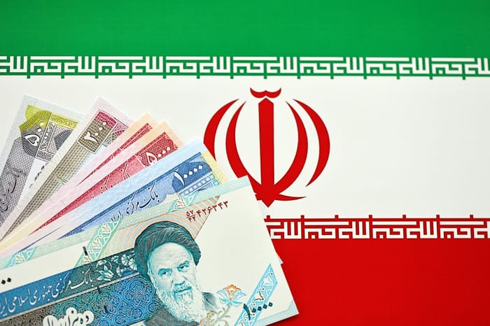 Iranian Rial IRR banknotes from Iran on flag of Islamic Republic of Iran close up