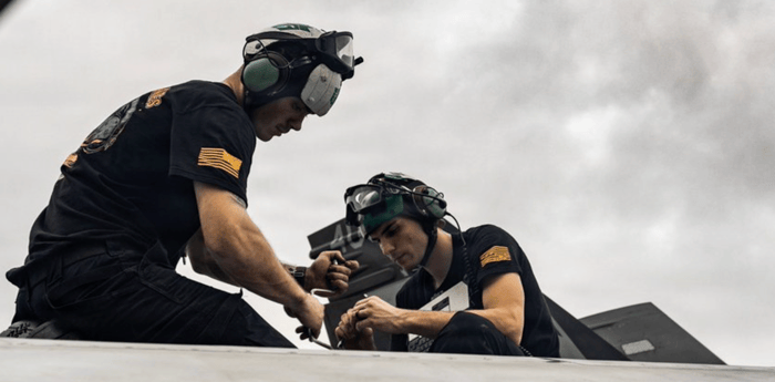 maintenance on F/A-18E Super Hornets on the flight deck of aircraft carrier USS Abraham Lincoln (CVN 72)