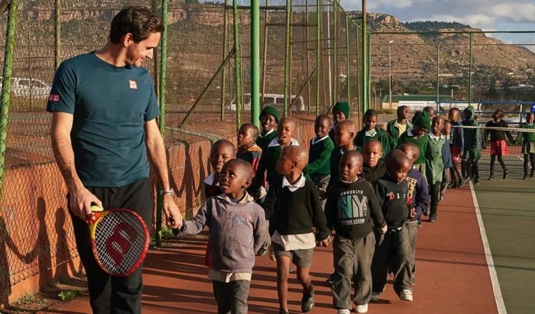 Federer with children supported by the foundation he established