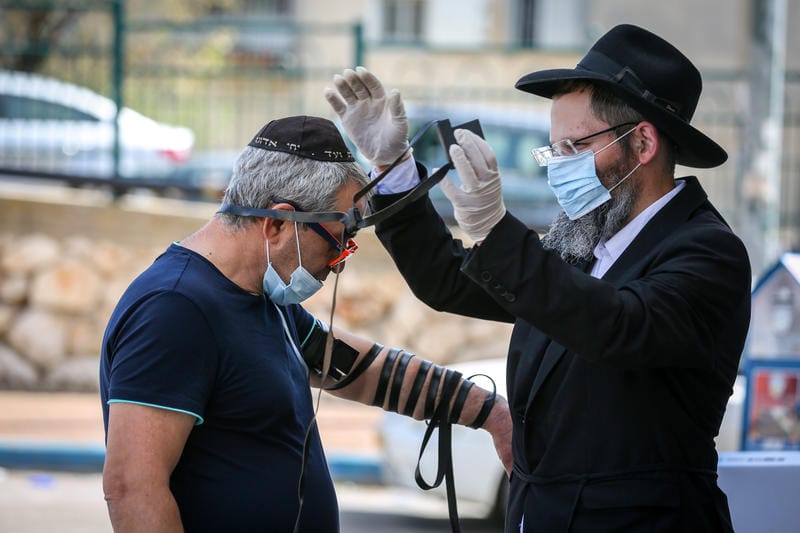 Orthodox Jewish men wear face masks as they pray, in Tzfat, April 03, 2020.