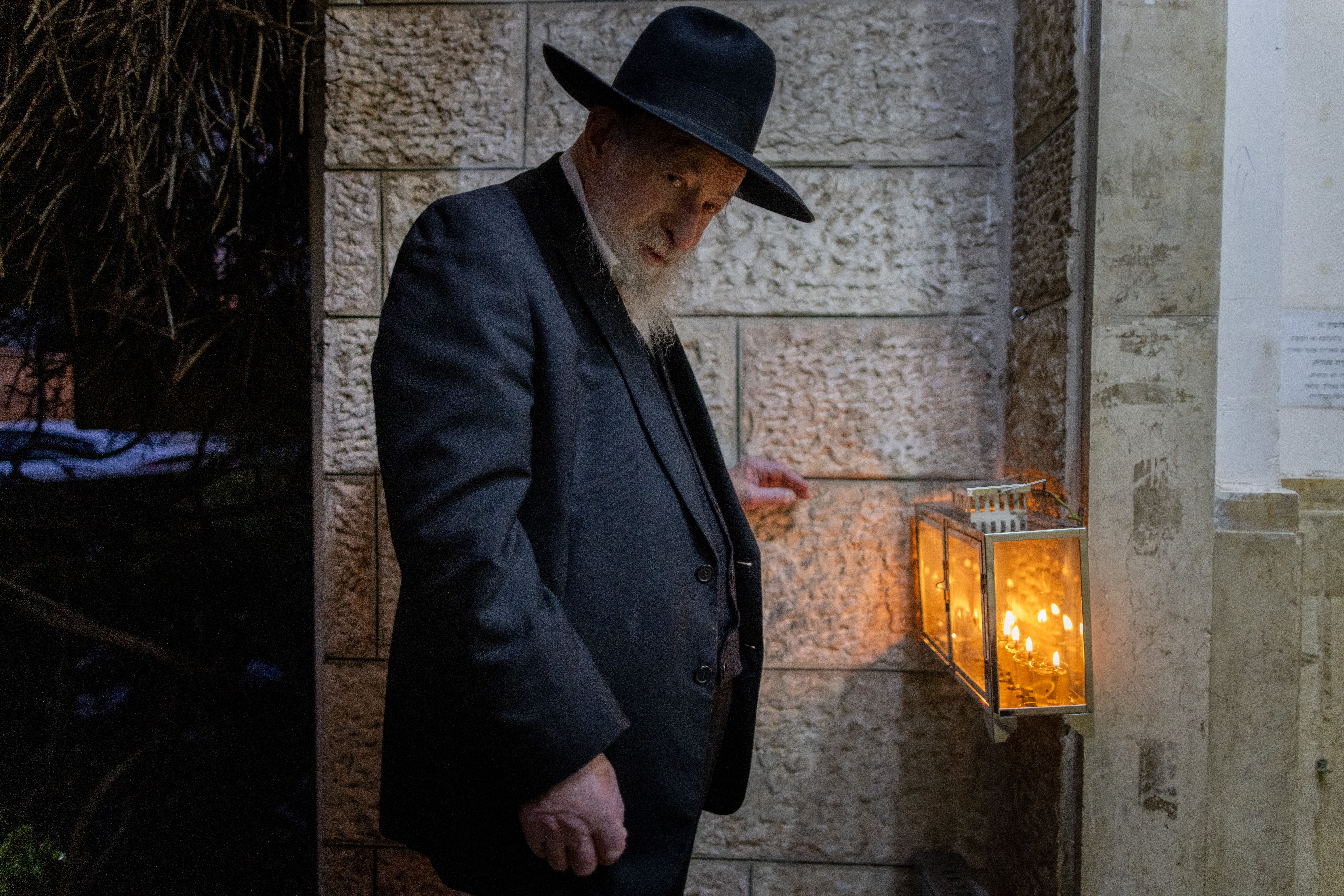 Holocaust survivor Rabbi Shmuel Geffen lights the Hanukkia (menorah) in Jerusalem's Ultra Orthodox Mea Shearim neighborhood, on the sixth night of the Jewish holiday of Hanukkah, December 30 2024