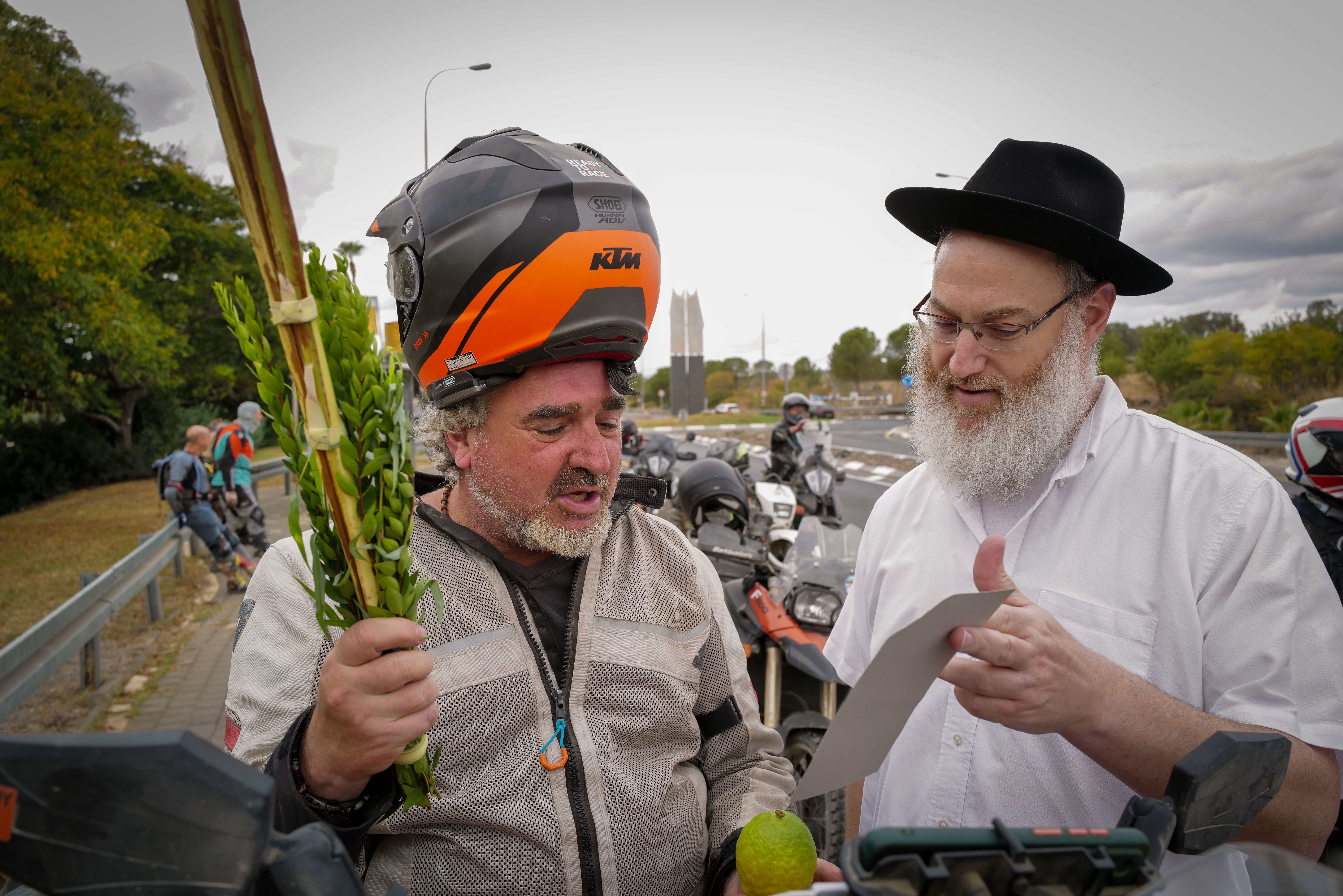 An orthodox Jew from the Habad organization offers a group of bikers to take part in the Mitzvah of the four species of the Sukkot Holiday in Katsrin, Golan Heights on October 1, 2023.