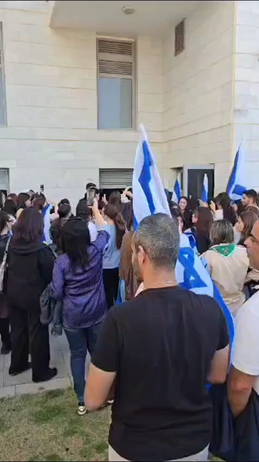 Israelis gather outside Agam Berger's building to celebrate her release