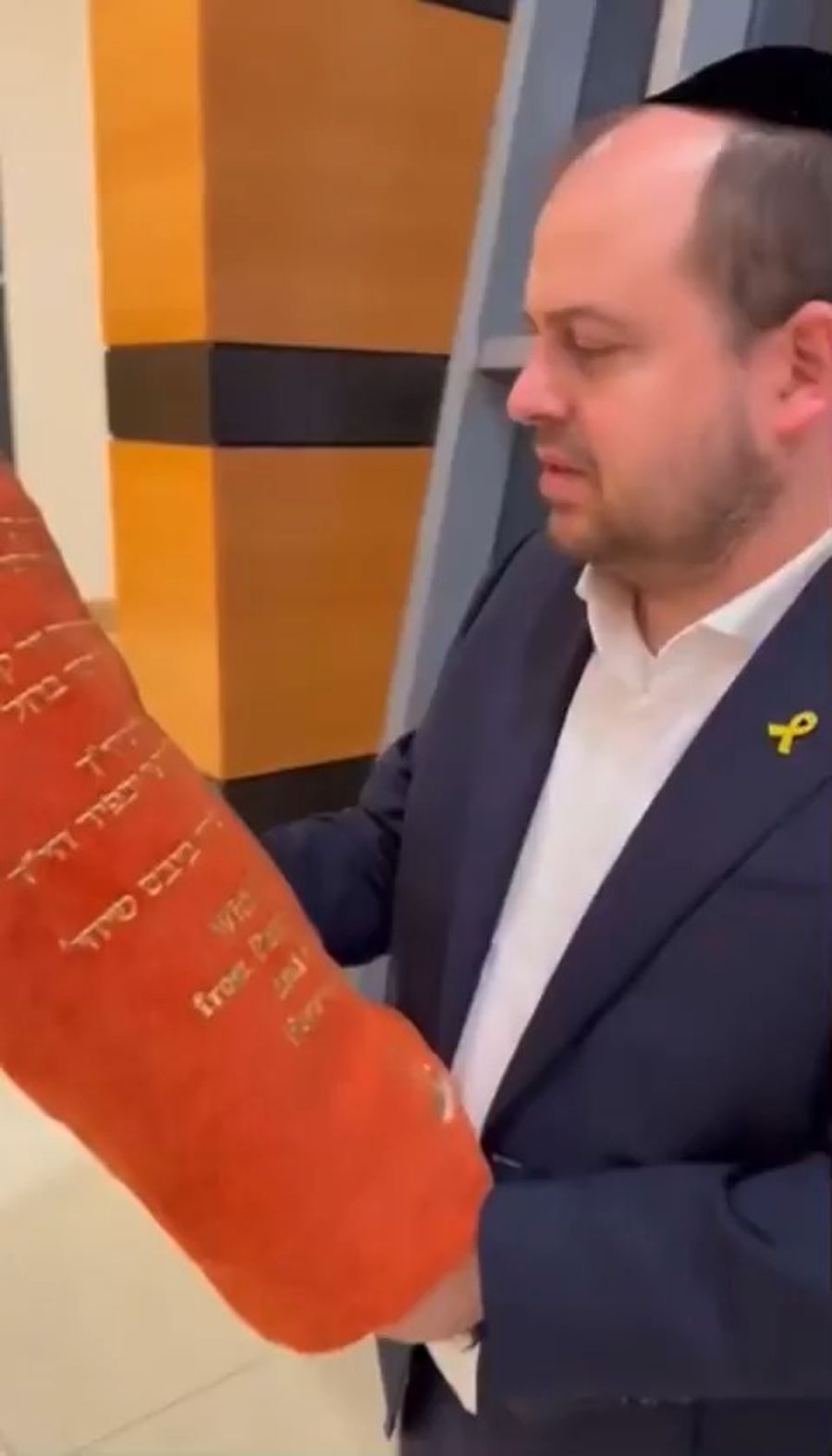 Shai Graucher displays the Torah scroll in memory of the Bibas family.