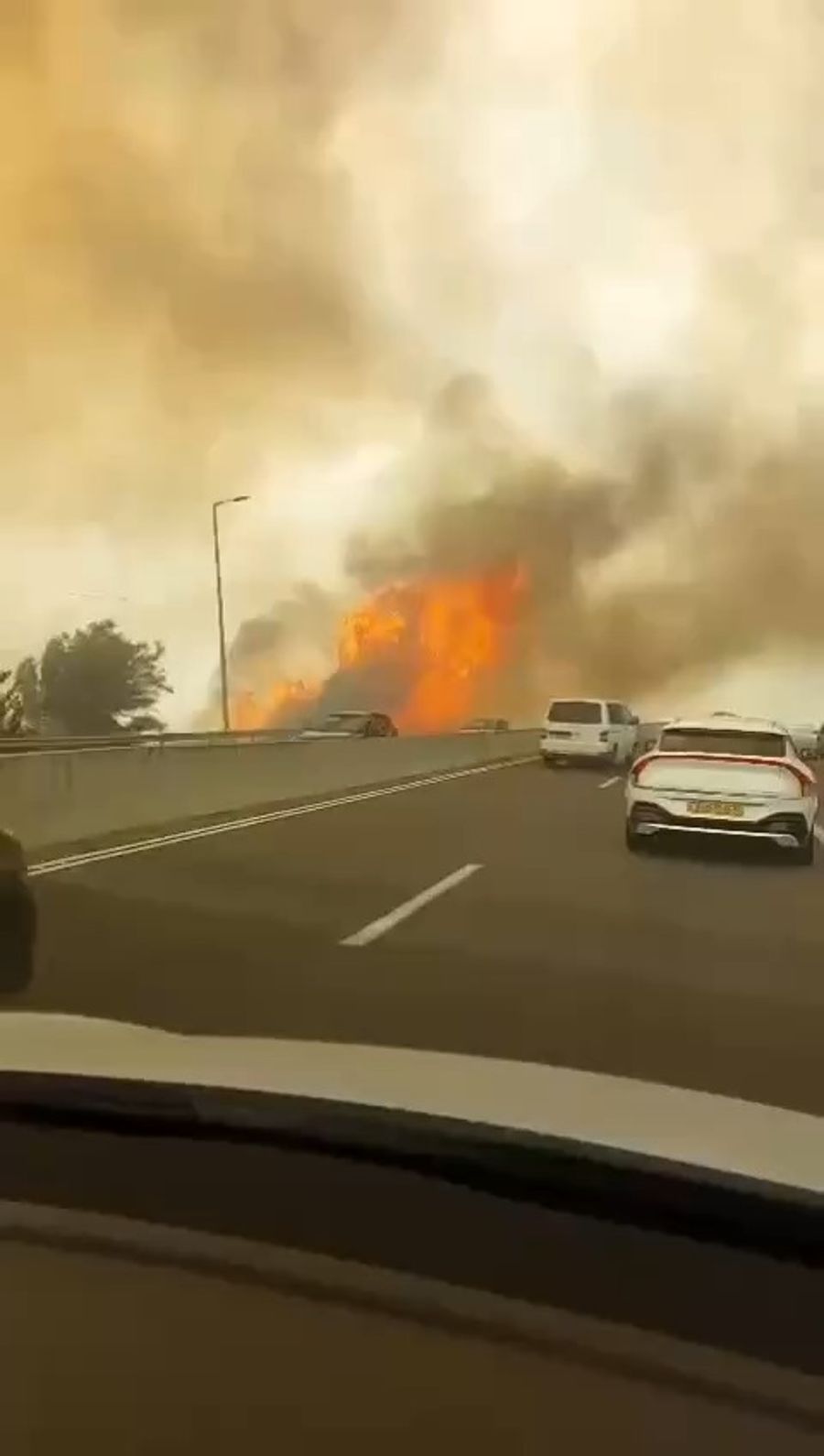 Drivers are forced to drive through flames to escape wildfires raging near Jerusalem