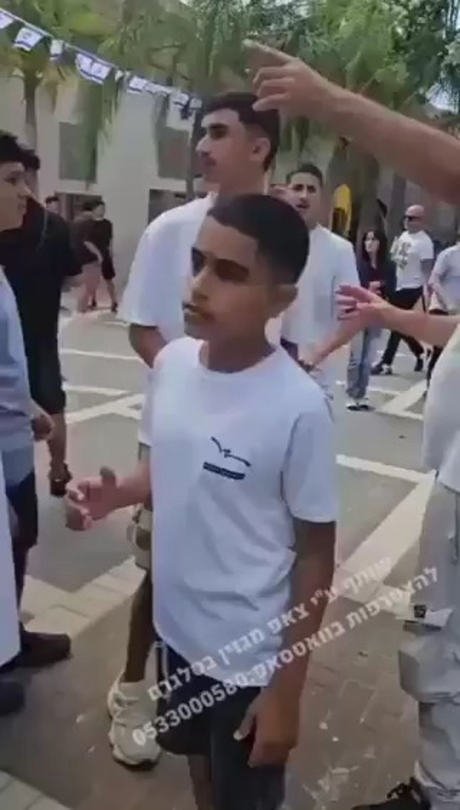 Students putting on tefillin aggressed by teacher