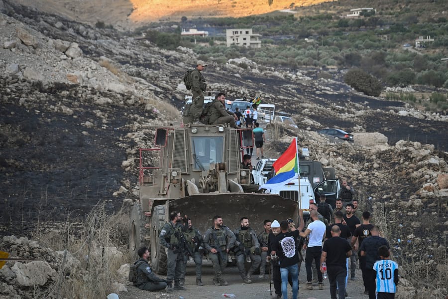 Druze residents protest near the Israeli-Syrian border fence in solidarity with their community in Syria, July 16, 2025. 
