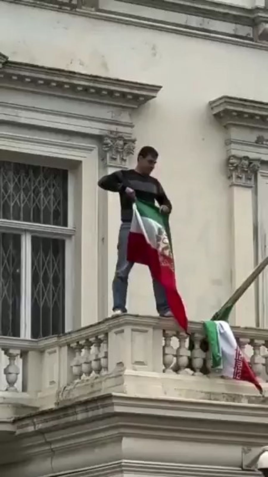 An Iranian protester removed the Islamic Republic flag and replaced it with the pre-1979 Lion and Sun flag at Iran’s embassy in London. 