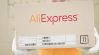 Warehouse worker holds box with printed ALIEXPRESS logo on 